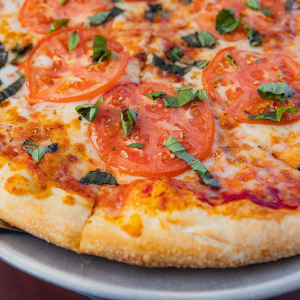 Grace's Place Pizzeria's Margherita pizza, topped with fresh tomatoes, mozzarella, and basil.
